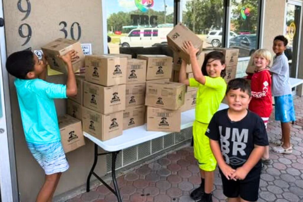 Students from Deeper Purpose Kids Academy help distribute food to community from Deeper Purpose's food pantry. Courtesy of DPCC