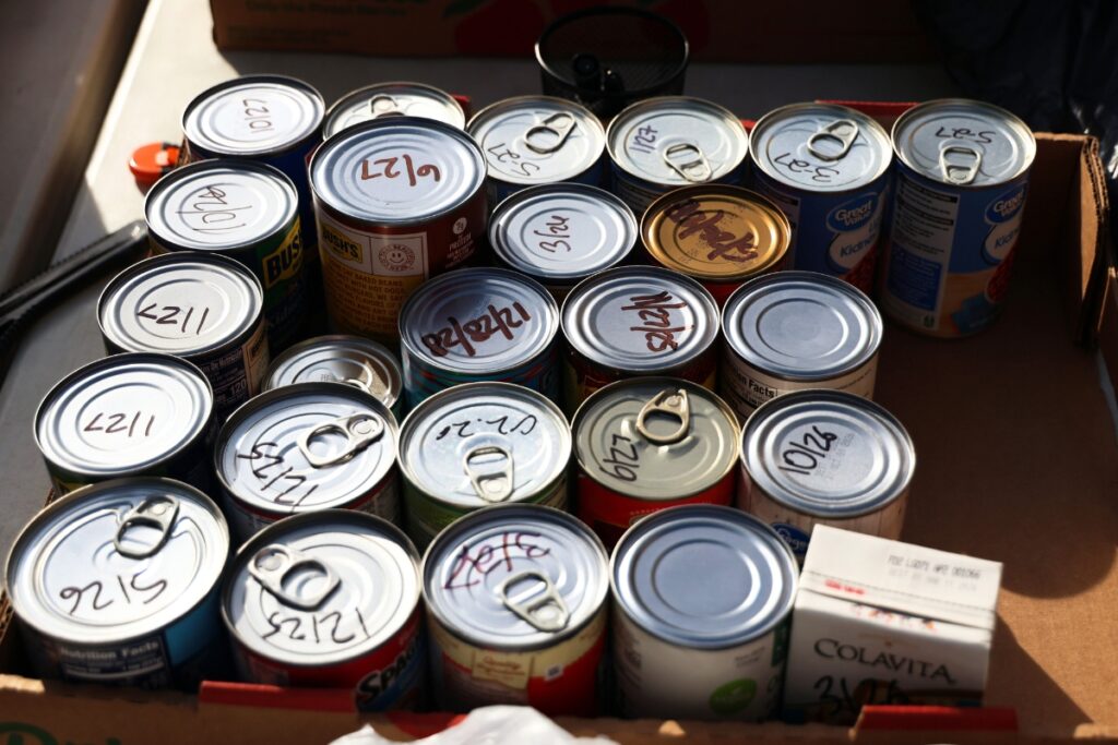 A box of sorted and dated canned goods sits on a folding table outside the Food4Kids warehouse in Gainesville on Tuesday. Photo by Libby Clifton