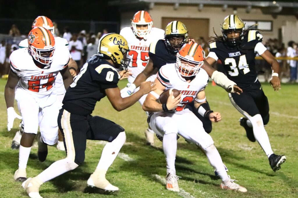 Buchholz defenders surround Eastside quarterback Nelson Tambling (13). Photo by C.J. Gish