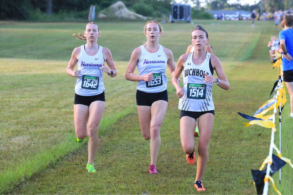 Buchholz runner Phoebe Verschage leads the Canes Elizabeth Rant (middle) and Keira Forbes (left). Photo by Seth Johnson