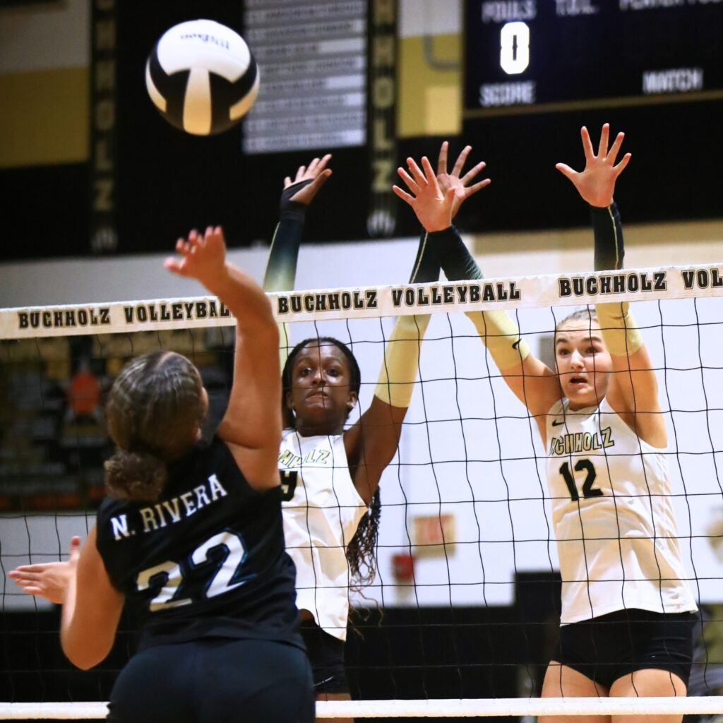 Buchholz's Aaliyah Ray (19) and Taylor Sembower (12) go for a block against West Port (Ocala). Photo by C.J. Gish
