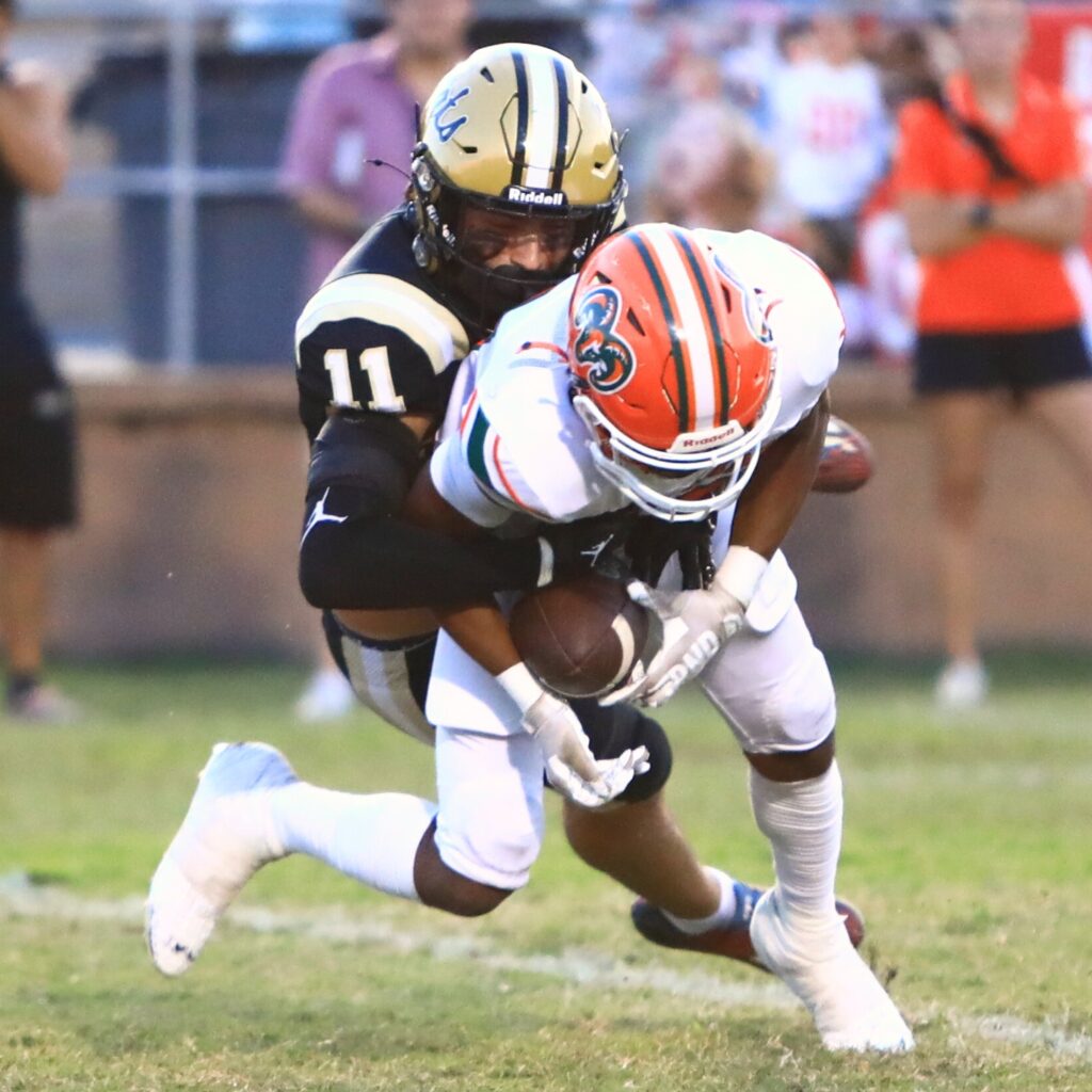Buchholz's Evan Amar (11) tackles Eastside's Jameer McCrathy (10). Photo by C.J. Gish