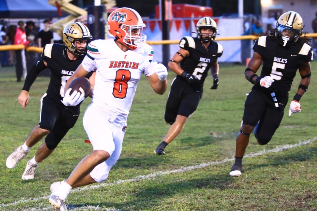 Eastside punter Antonio Cortez (8) runs from Buchholz defenders after a first-quarter snap went over his head on fourh down. Photo by C.J. Gish