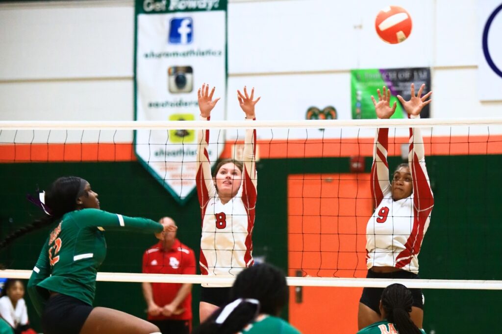 Eastside's Anijah Goss (12) with a hit against Dixie County's Rhyann Hatcher (8) and Kiersten Brown (9). Photo by C.J. Gish