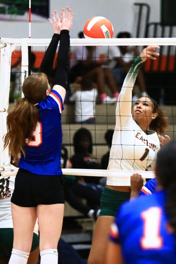 Eastside's Kaylee Ovia (1) with a hit against P.K. Yonge's Nina Bennett (3). Photo by C.J. Gish