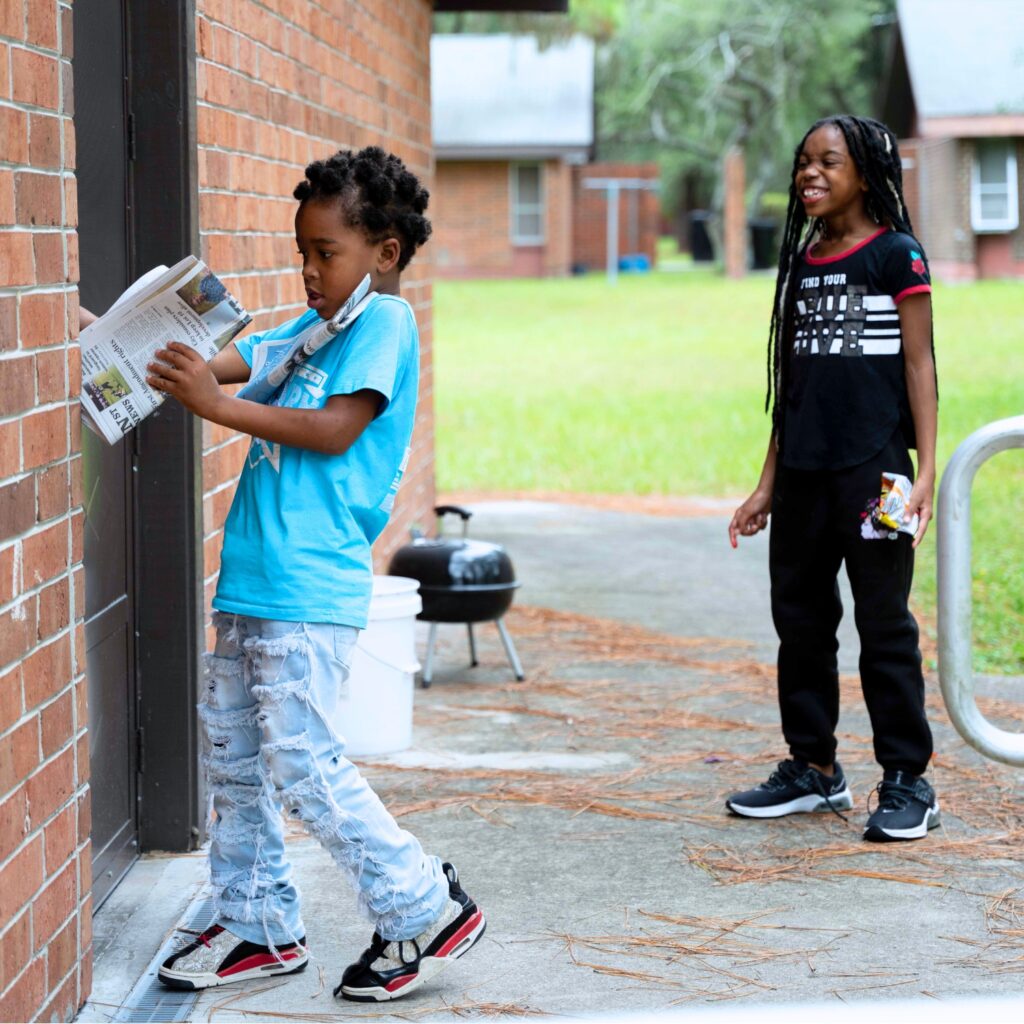 GHA's deliverers leaving a Mainstreet newspaper at a residence in east Gainesville. Photo by Tim Rodriquez