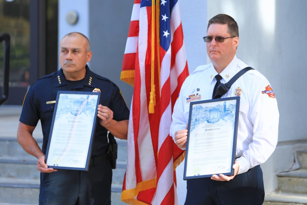 Gainesville Police Chief Nelson Moya (left) and Fire Chief Joseph Hillhouse hold proclamations declaring Thursday as Patriot Day in the city. Photo by Seth Johnson