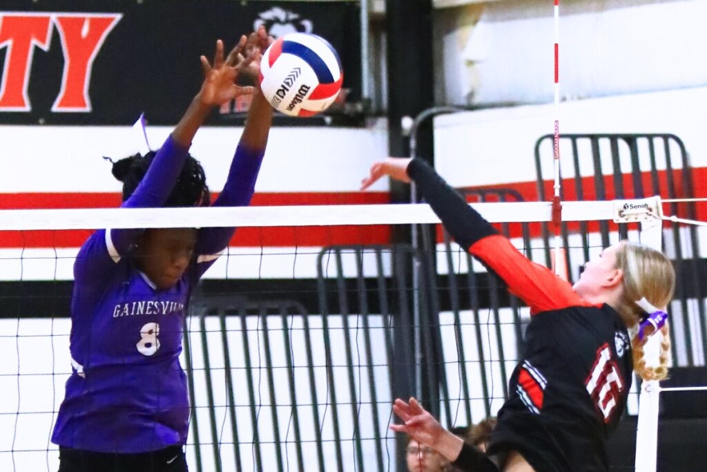 Gainesville's Jorryn Dye (8) blocks a hit by The Rock's Callie Kieszeck (16). Photo by C.J. Gish
