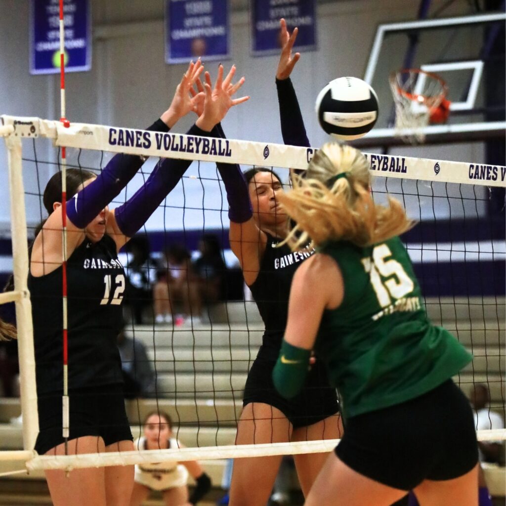 Gainesville's Sloane Childers (12) and Jacey Carter-Mitchell (1) go for a block against Forest (Ocala). Photo by C.J. Gish