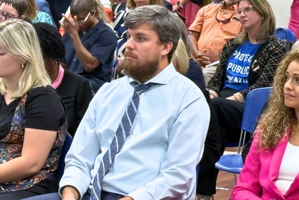 Jeremy Clepper (left) waits to be called on to speak at the Aug. 20 State Board of Education meeting. Photo by Gary Nelson