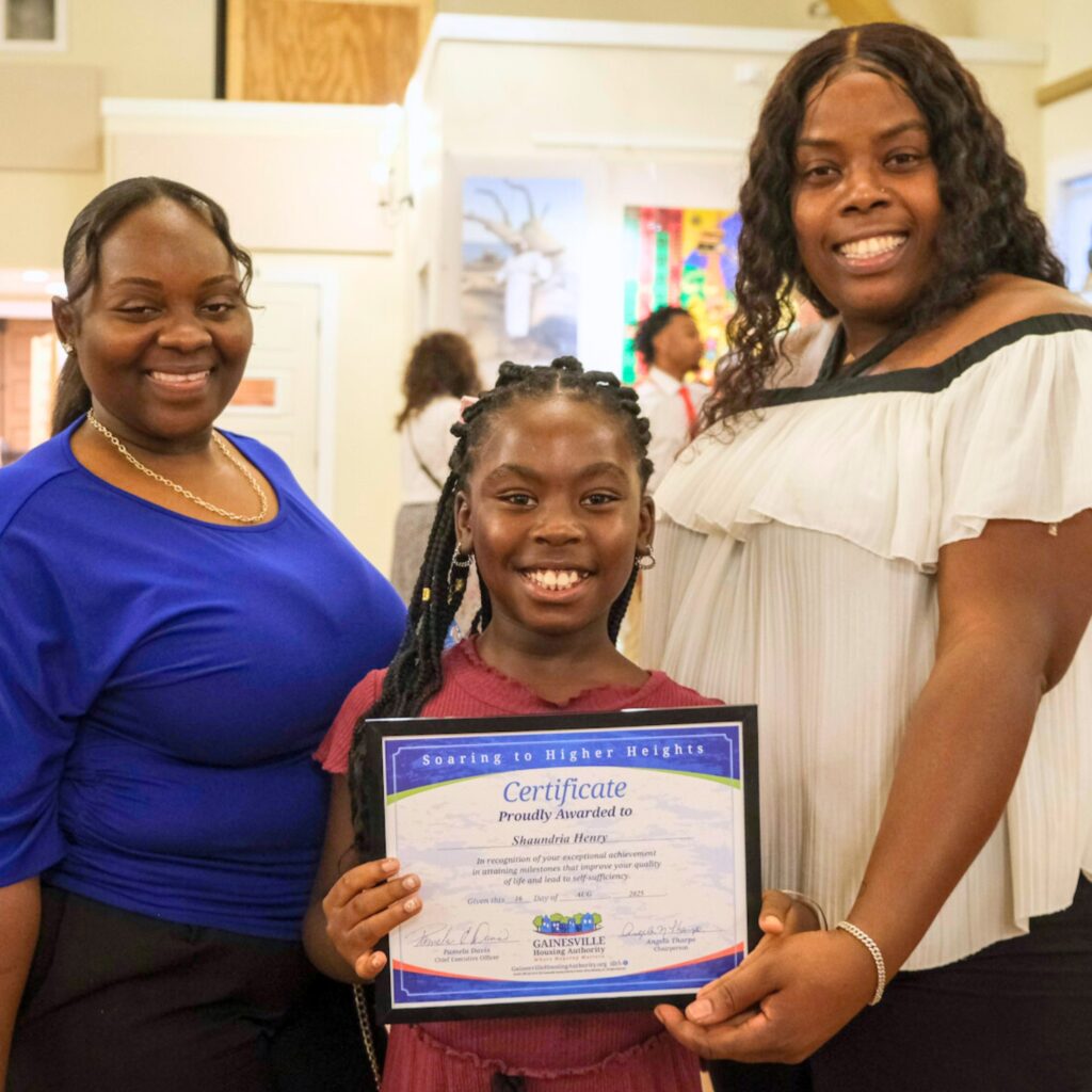 Junior Newspaper Deliverer Amaya Davis (center) from GHA's Lake Terrace group is recognized at GHA's Celebration of Success. Courtesy of Ardry Henderson (1)
