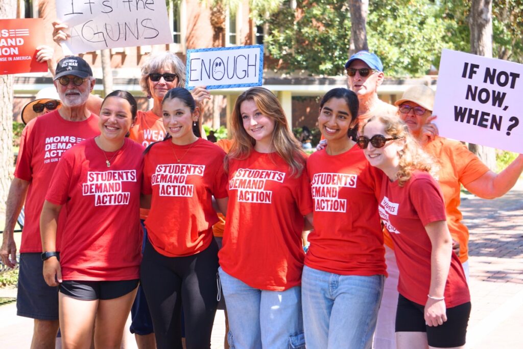 Members of the University of Florida Students Demand Action and Alachua County’s Moms Demand Action hold homemade signs before the Walkout for Safer Schools. Photo by Kirsten Rabin