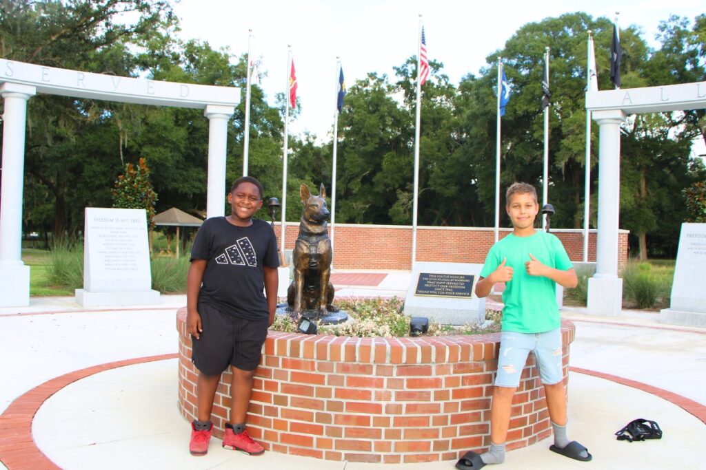 Newberry students Ah'mir Garrison (left) and Tobias McNeal (right) are told to respectively observe the Veterans Memorial after its eight flags were stolen in August. Photo by Lillian Hamman