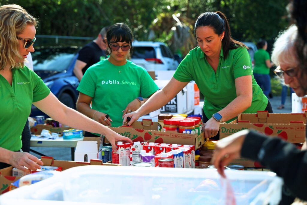 Publix associates Christine Musial (right) works alongside her coworker Stephanie Brumlop (left) to check expiration dates while sorting food donations at the Food4Kids warehouse in Gainesville