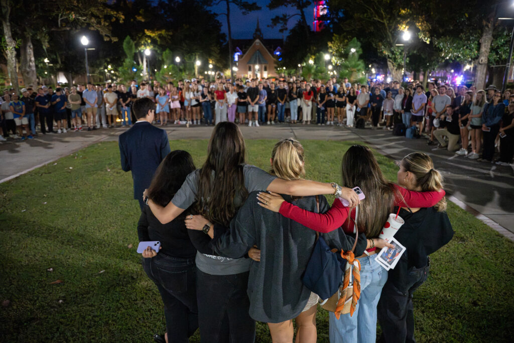 Students with Turning Point USA at UF link arms as students remember Charlie Kirk's impact on their lives.