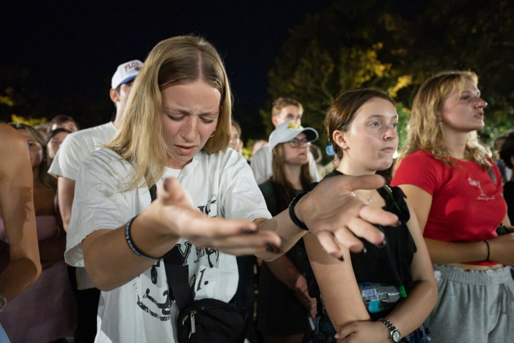 A UF student sings at a prayer vigil for Charlie Kirk.