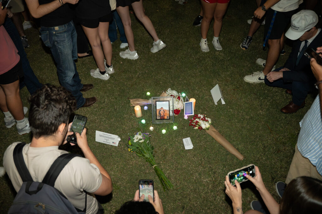 UF students take photos of a vigil remembering Charlie Kirk, who visited the campus in February 2025.