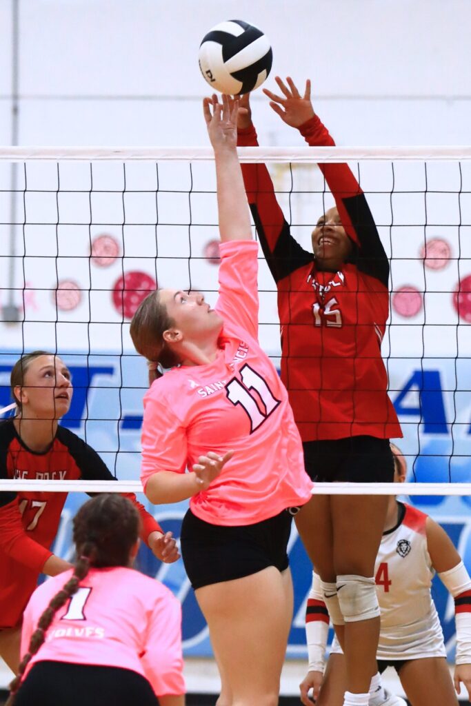Saint Francis Catholic's Morgan Ritten (11) and The Rock's Holdyn Moore (15) battle at the net. Photo by C.J. Gish