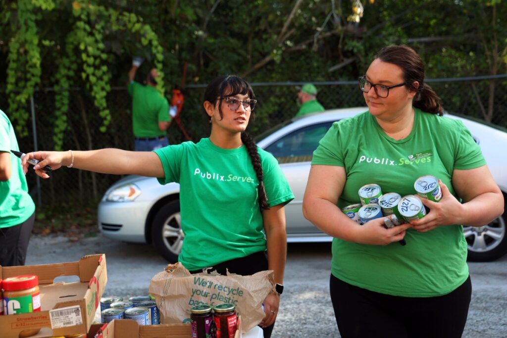Stephanie Brumlop (left) guides a volunteer sorting canned items at the Food4Kids warehouse in Gainesville on Tuesday. Photo by Libby Clifton