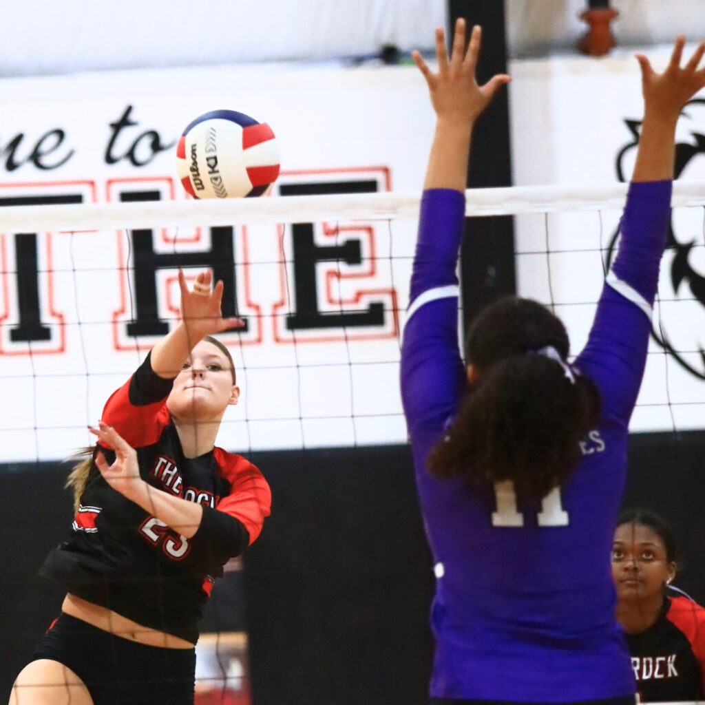 The Rock's Alexis Rhoden (23) with a hit against Gainesville's Kenzie Carter-Mitchell (11). Photo by C.J. Gish