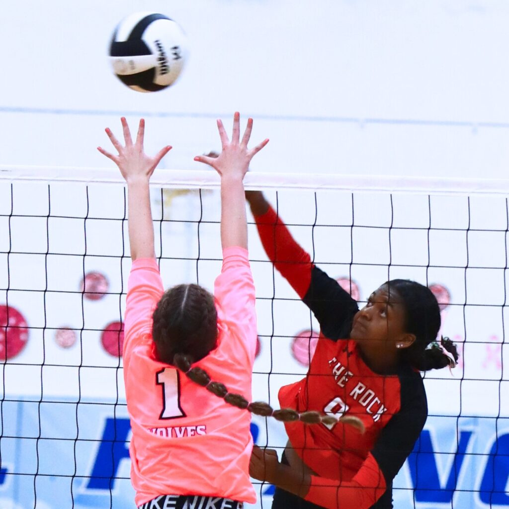 The Rock's Ari Howard (9) with a hit against Saint Francis Catholic's Gabrielle Rosado (1). Photo by C.J. Gish