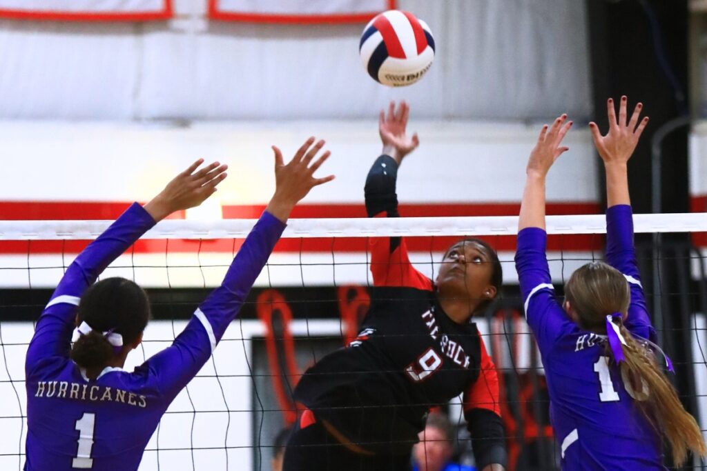 The Rock's Arianna Howard (9) with a hit against Gainesville's Jacey Carter-Mitchell (1) and Charlotte Judge (10). Photo by C.J. Gish