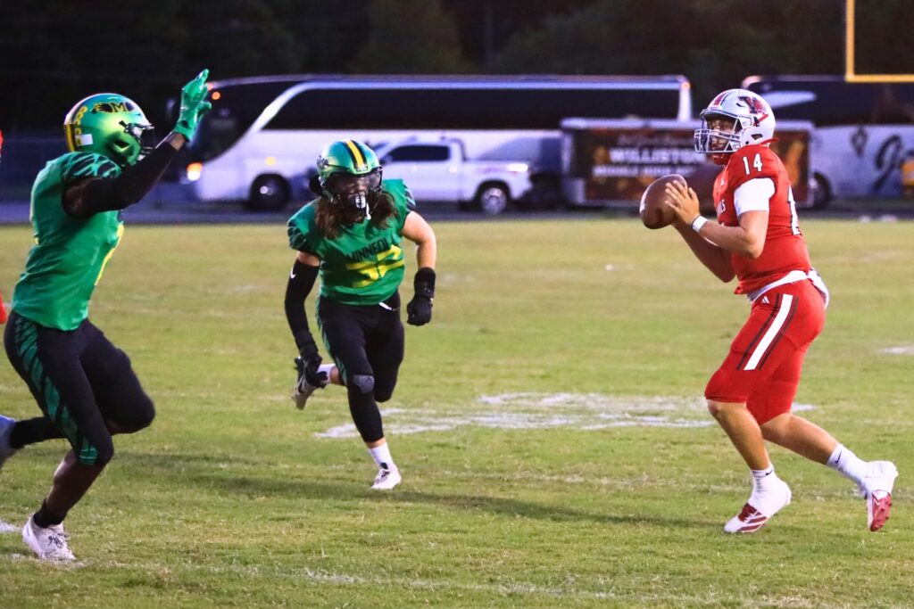 Williston quarterback John Jazikoff (14) looks downfield to throw against Lake Minneola. Photo by C.J. Gish