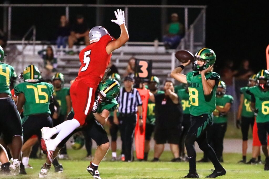 Williston's Chris Roush (5) pressures the Lake Minneola quarterback. Photo by C.J. Gish