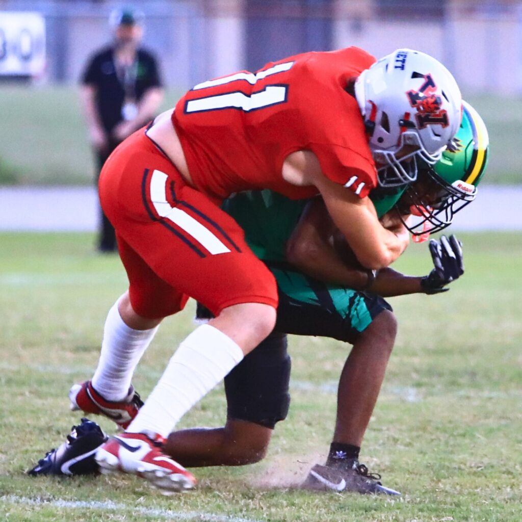 Williston's Danny Burchett (11) tackles a Lake Minneola receiver. Photo by C.J. Gish