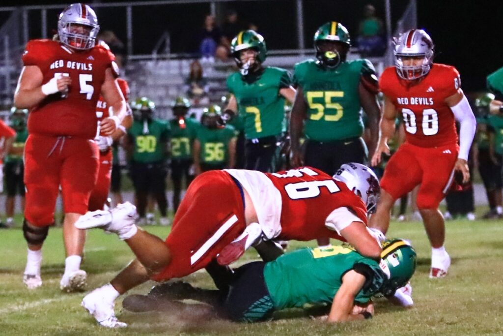 Williston's Steve Jennings (56) smothers a Lake Minneola runner. Photo by C.J. Gish
