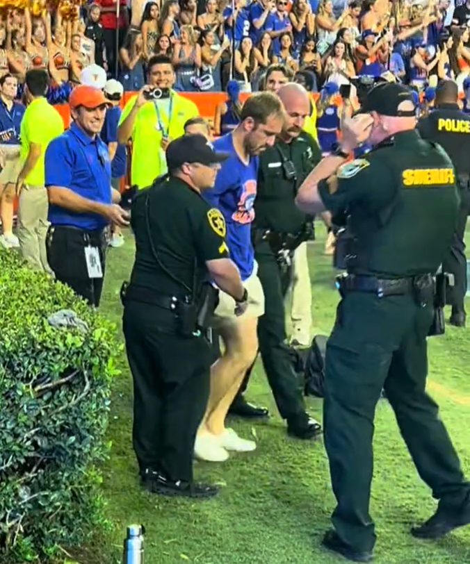 John Paul Schmidt, 27, of Greensboro, N.C., is taken in to custody by Alachua County Sheriff’s Deputies following Florida’s 29 - 21 win over Texas on Saturday, Oct. 4, 2025. (Screengrab via Tiktok/@sidehustlehustle)