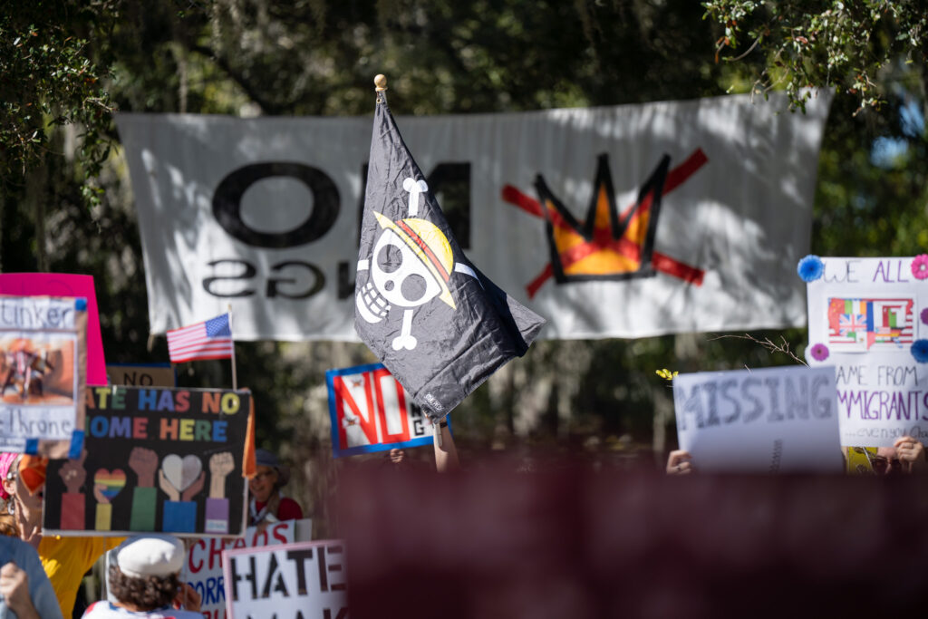 A One Piece_ flag is flown at the No Kings Gainesville protest. The One Piece flag has become a symbol of freedom and rebellion for Gen Z-led protests against corruption and authoritarianism