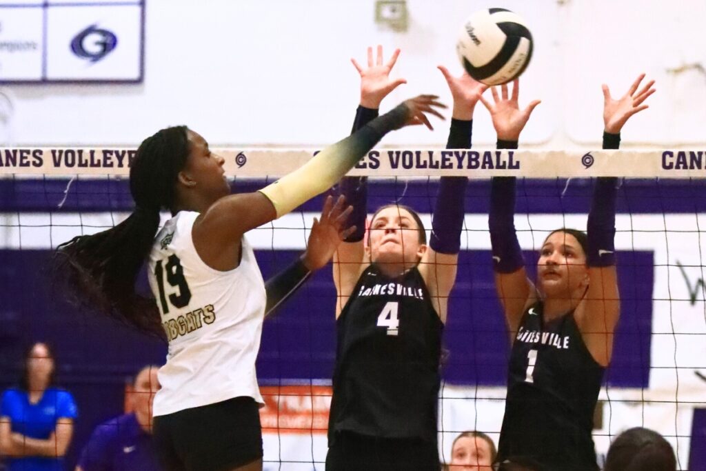 Buchholz's Aaliyah Ray (19) attempts a hit against Gainesville's Rowan Kage (4) and Jacey Carter-Mitchell (1). Photo by C.J. Gish