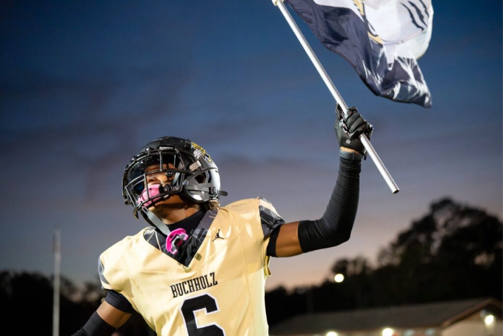Buchholz's Ja'marionn Garcia carries a flag onto the field against Bartram Trail (St. Johns) at the beginning of the game. Photo by Tim Rodriquez