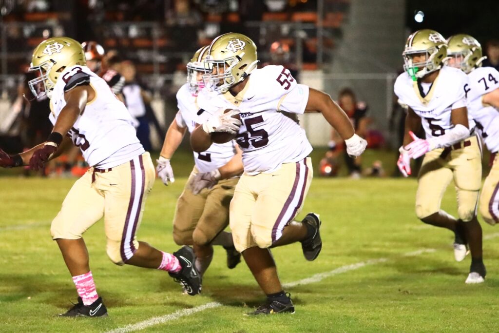 Oak Hall's Andrew Akins (55) picks up a Trenton fumble in the closing seconds of the first half. Photo by C.J. Gish