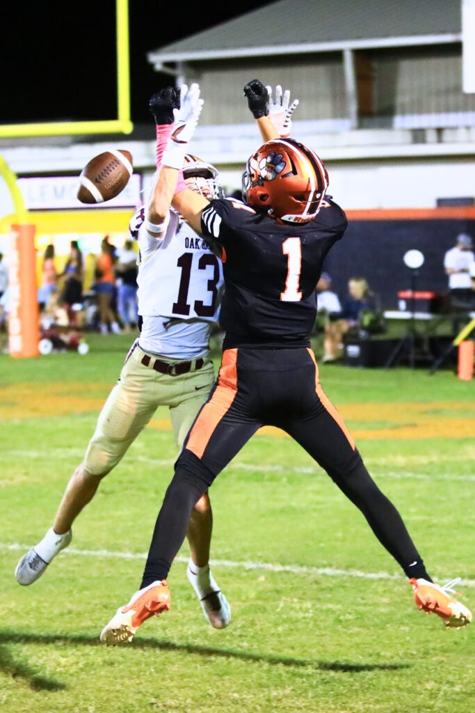 Oak Hall's Bradley Wise (13) breaks up a first-quarter pass intended for Trenton's Brant Bivens (1). Photo by C.J. Gish