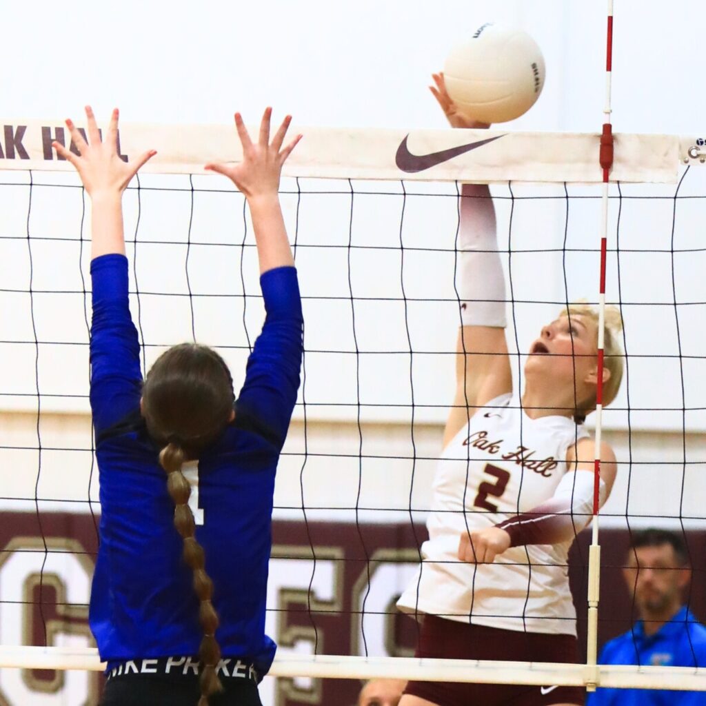 Oak Hall's Lizzie Cannon (2) with a hit against Saint Francis Catholic's Gabrielle Rosado (1). Photo by C.J. Gish
