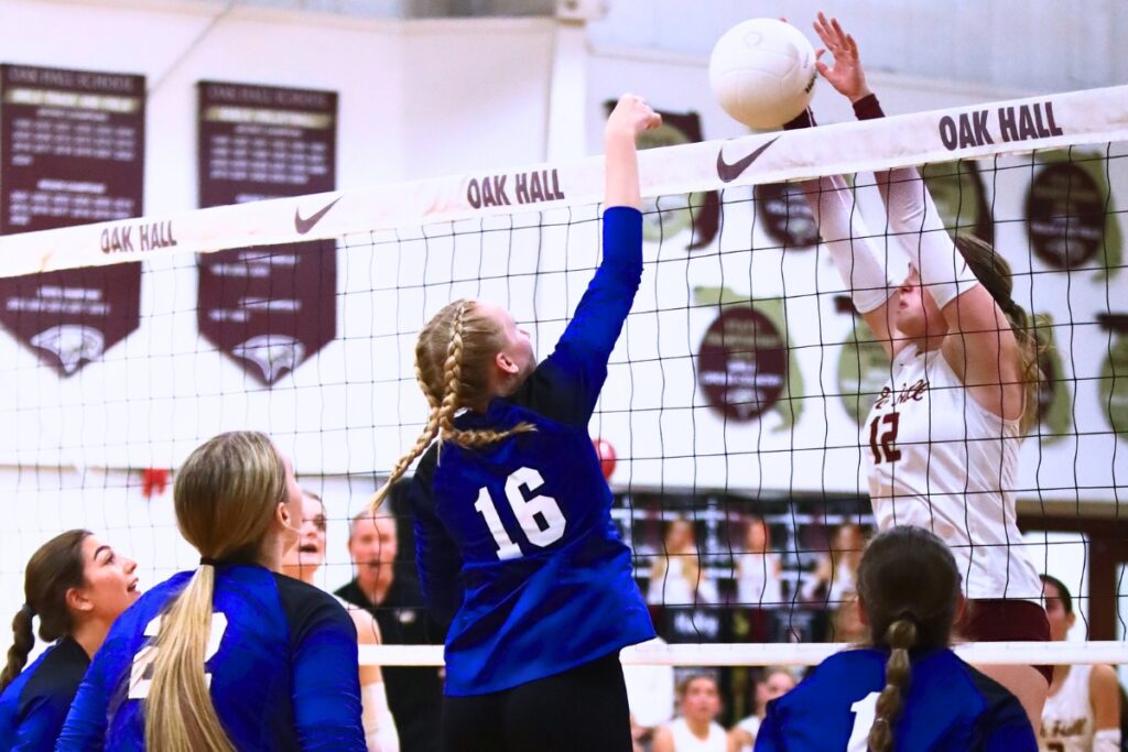 Oak Hall's Paige Sherrod (12) goes for a block against Saint Francis Catholic's Hailey Schoster (16). Photo by C.J. Gish