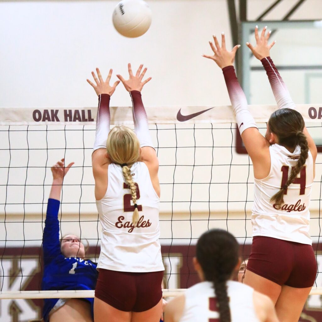 Saint Francis Catholic's Gabrielle Rosado (1) with a hit against Oak Hall's Kendylle Bishop (14) and Lizzie Cannon (2). Photo by C.J. Gish