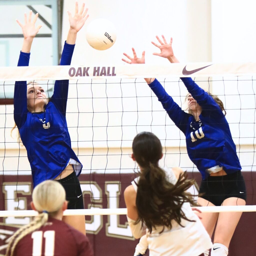 Saint Francis Catholic's Katelyn Elder (8) and Hannah Ulmer (10) go for a block against Oak Hall's Kaitlin Allen (3). Photo by C.J. Gish