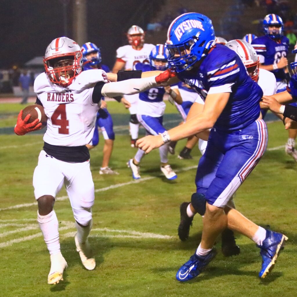 Santa Fe's Keimarion Neal (4) stiff arms a Keystone Heights defender. Photo by C.J. Gish