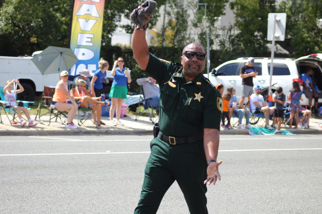 Sheriff Chad Scott does the Gator Chomp during the UF Homecoming Parade