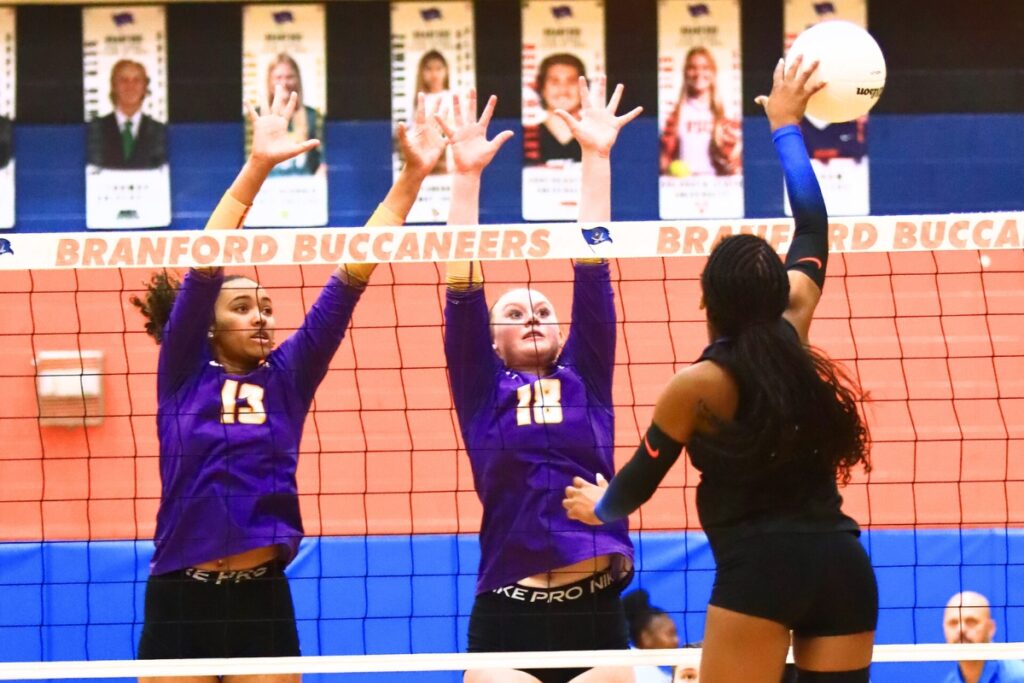 Union County's Jailyn Simmons (13) and Morgan Smith (18) attempt to block a hit by Branford's Kaleah Tucker (1). Photo by C.J. Gish