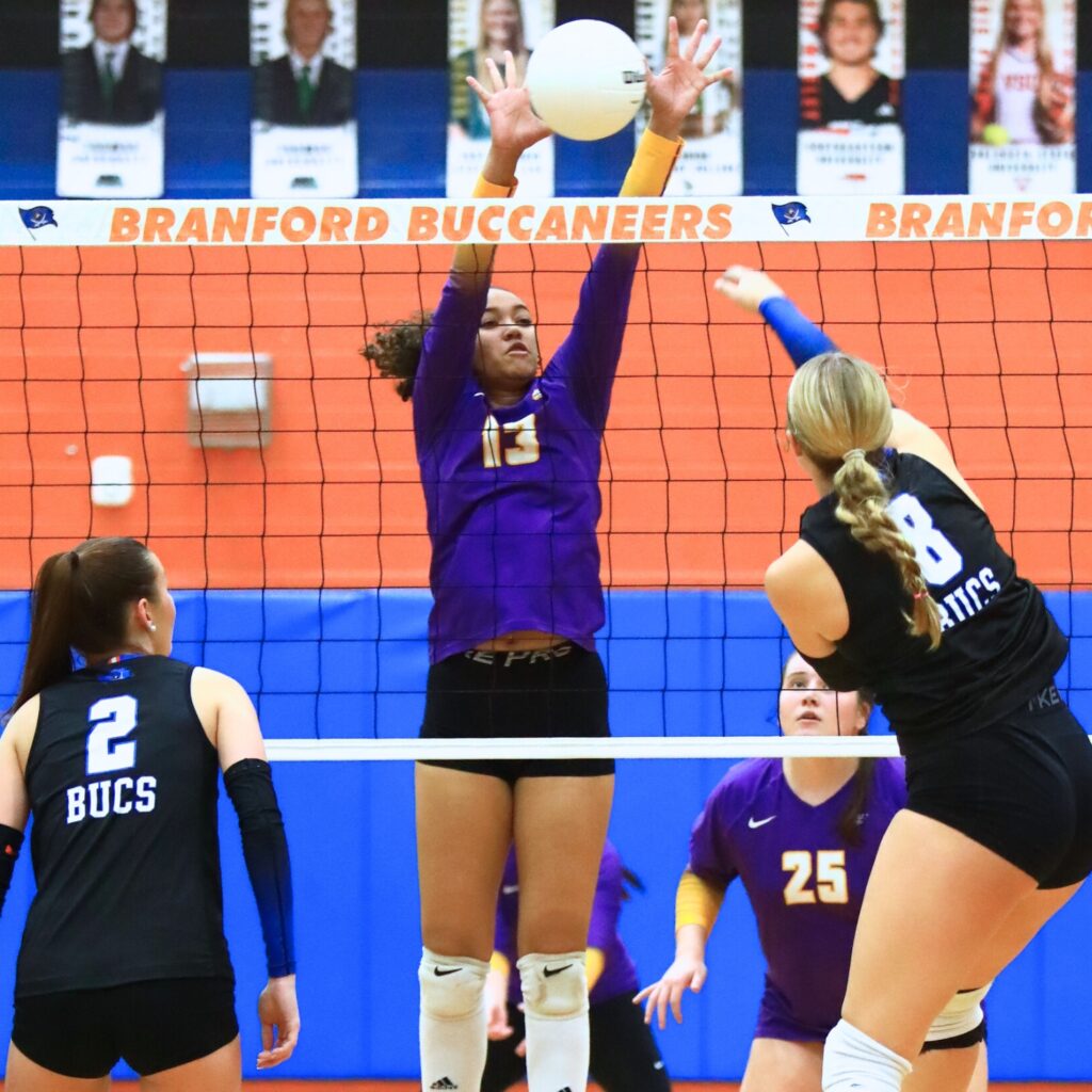 Union County's Jailyn Simmons (13) goes for a block against Branford's Anabella Dicks (8). Photo by C.J. Gish