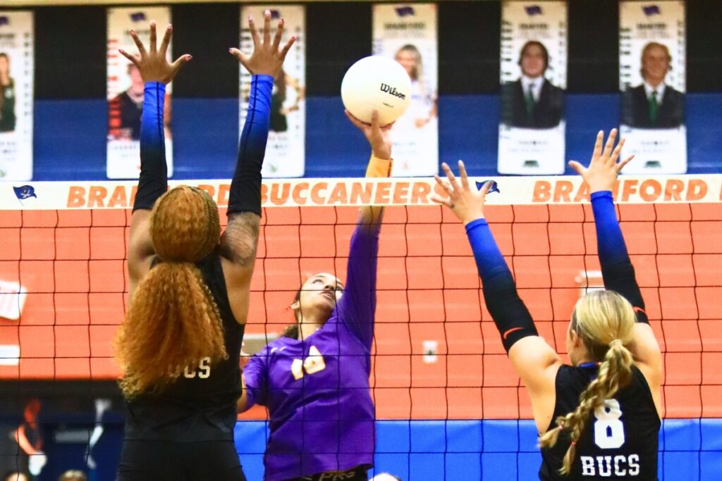 Union County's Jailyn Simmons (13) with a hit against Branford's Adriauna Combs (4) and Anabella Dicks (8). Photo by C.J. Gish