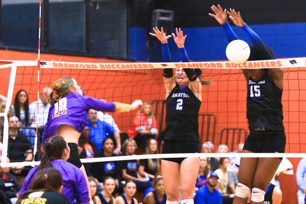 Union County's Mallory Waugh (10) with a hit against Branford's Mylie Fernandez (2) and Mallory Blue (15). Photo by C.J. Gish