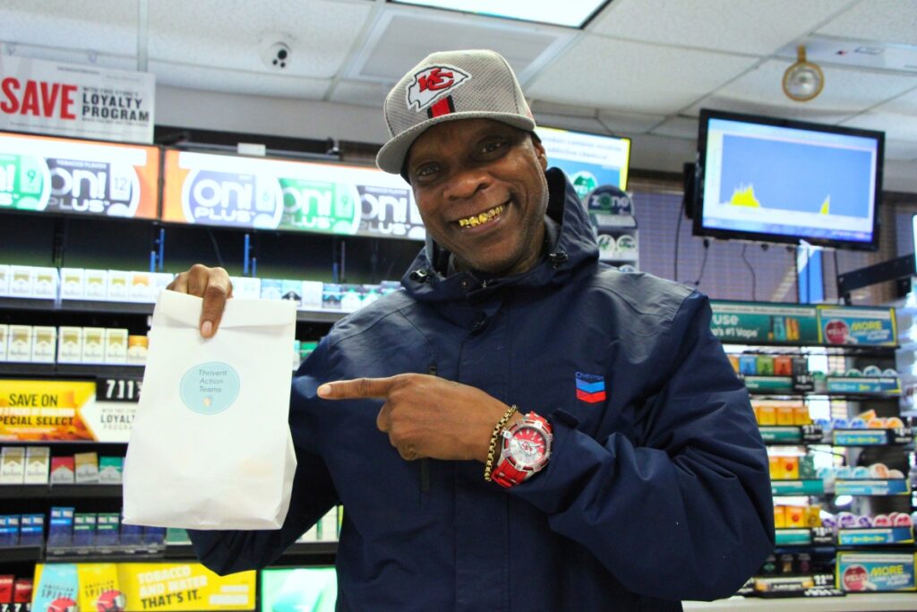 A Chevron gas station clerk distributes Operation Turkey Sandwich lunches to his employees. Photo by Lillian Hamman
