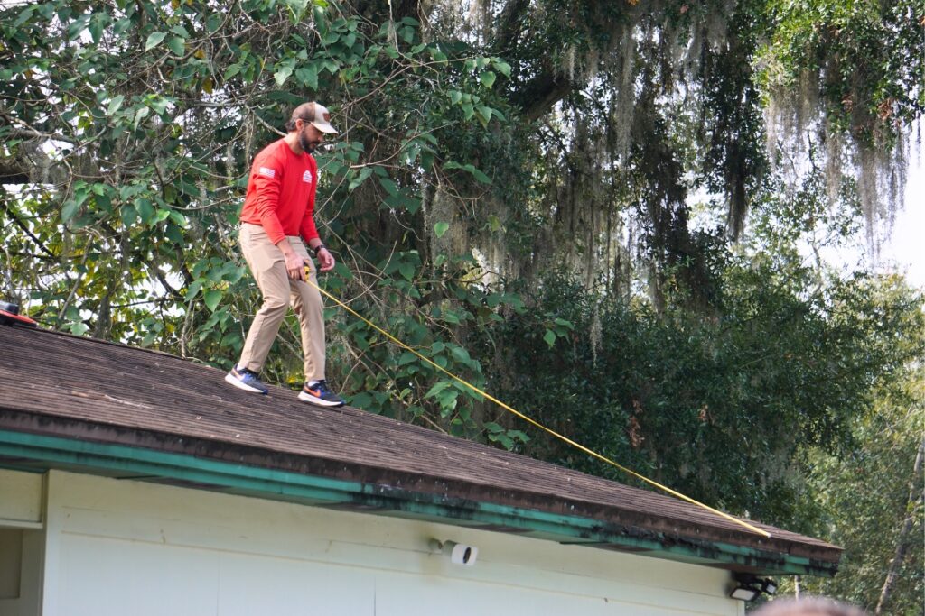 An Action Roofing employee takes measurements of the roof the company will be replacing for Mike S. in Gainesville. Photo by Kirsten Rabin