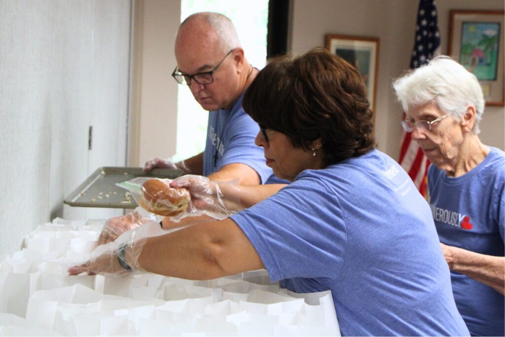 Gethsemane Lutheran Church's pastor Dale Raatz (left) helps church members package Thanksgiving lunches. Photo by Lillian Hamman