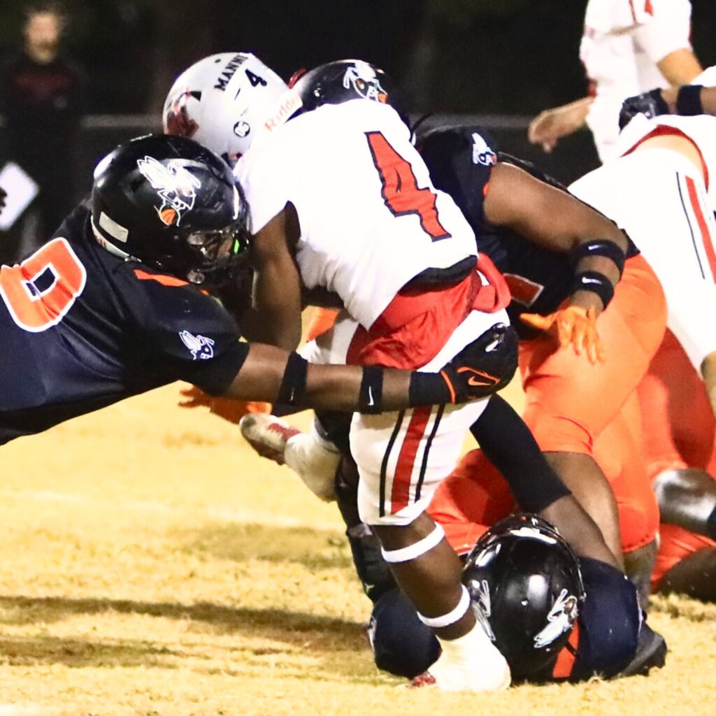 Hawthorne defenders bring down Williston's Kameryn Manneh (4) in the Rural-Region 4 Final. Photo by C.J. Gish